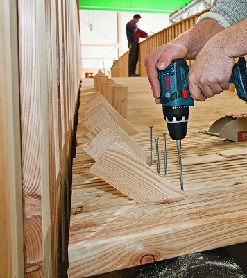 Man driving a screw in to a floor board